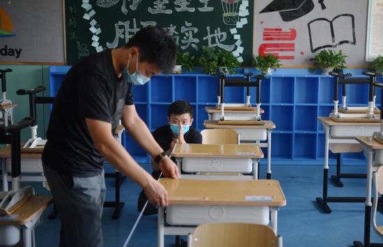 8月24日，北京教育学院附属丰台实验学校，教师根据地面的标识码放桌椅。