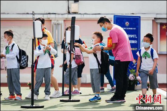 向阳小学老师引导低年级孩子有序入校。向阳小学供图