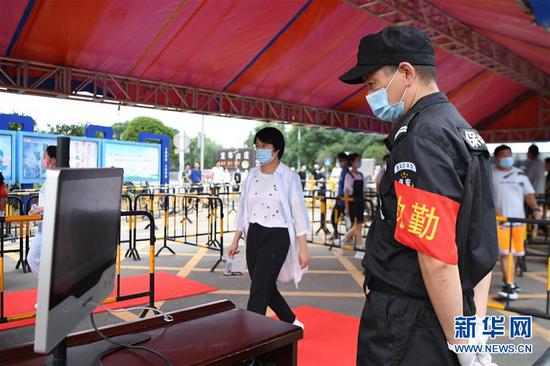 7月3日，工作人员（右）在长沙市周南中学模拟查看入场考生的体温检测结果。新华社记者 薛宇舸 摄