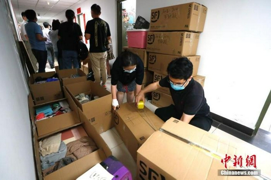 资料图:2020年,中国人民大学的教职工为不能返校的毕业生打包行李。中新社记者 富田 摄