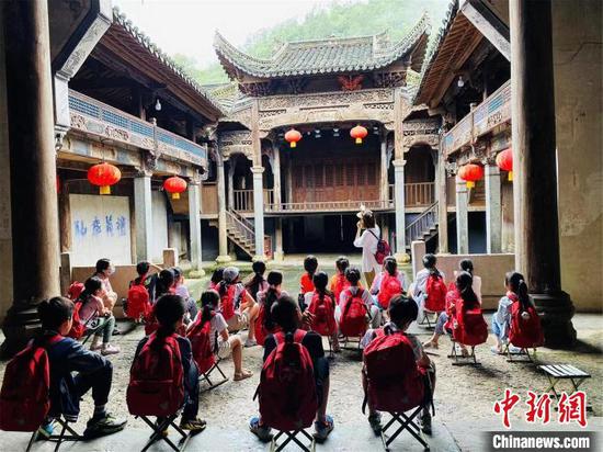 图为孩子们在一处历史建筑前接受革命传统文化教育。李明明摄