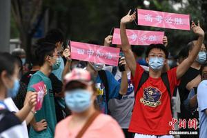 资料图：2020年7月10日，北京高考最后一日，部分2019届北京四中毕业生手持加油横幅，为学弟妹们加油打气。中新社记者 崔楠 摄