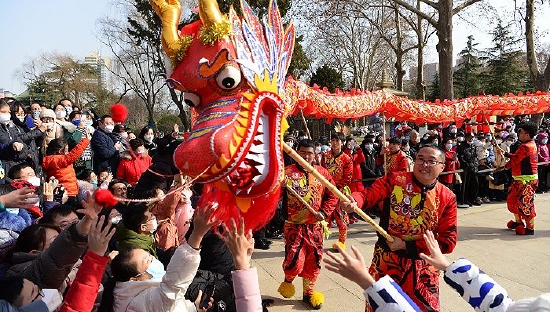 2023年1月28日，西安，2023年春节期间，兴庆宫公园，游园的市民们兴高采烈的围在一起观看舞龙舞狮闹新春。图片来源：人民视觉