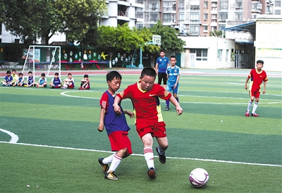 迎新乡小学（红队）和市里的一支俱乐部球队正在踢一场友谊赛。