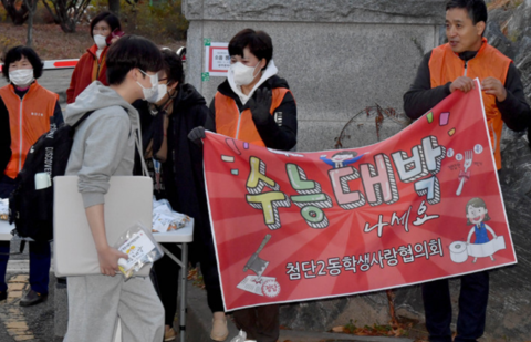 11月17日,韓國民眾在考場外為考生加油打氣。(紐西斯通訊社)