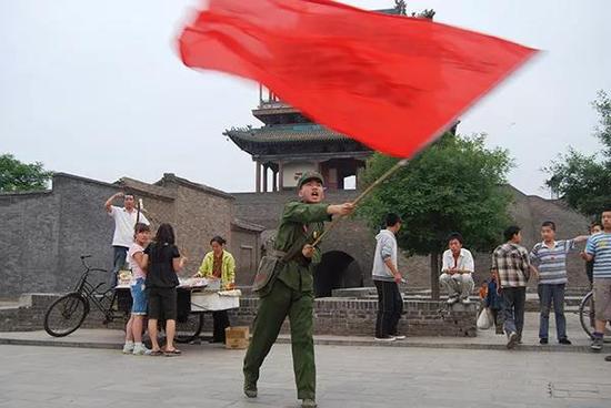 赵昶通在平遥街头挥舞国旗. 本文图片均为受访者供图