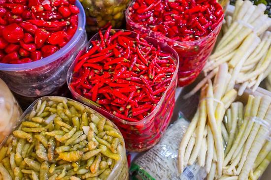 在汇川区的各大菜市场中，不同种类的酸味腌制品极为常见。光是酸制的辣椒便有糟辣椒、泡椒等多种。摄影/韩诗扬