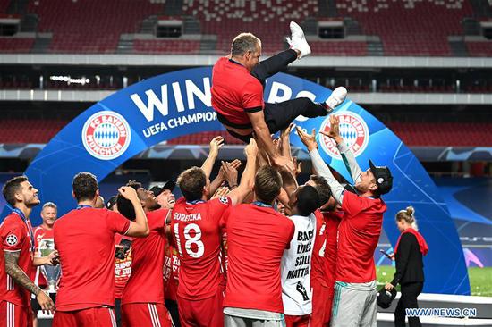 Hans-Dieter Flick (top), head coach of FC Bayern Munich, is thrown into the air by his players following their team's victory in the UEFA Champions League Final match between Paris Saint-Germain and Bayern Munich at Estadio do Sport Lisboa e Benfica in Lisbon, Portugal, Aug. 23, 2020. (Photo by Michael Regan/UEFA via Xinhua)