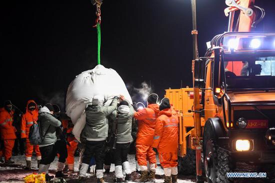 Staff members transport the return capsule of China's Chang'e-5 probe in Siziwang Banner, north China's Inner Mongolia Autonomous Region, on Dec. 17, 2020. The return capsule of China's Chang'e-5 probe touched down on Earth in the early hours of Thursday, bringing back the country's first samples collected from the moon, as well as the world's freshest lunar samples in over 40 years. (Xinhua/Peng Yuan)