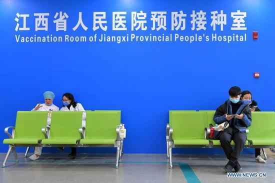 People wait to receive their COVID-19 vaccinations at the vaccination room of Jiangxi Provincial People's Hospital in Nanchang, capital of east China's Jiangxi Province, Jan. 4, 2021. Key groups with higher risks of infection, including frontline medical workers, customs inspectors of imported cold-chain goods and personnel working in the overseas and domestic transportation sector, began to receive their first COVID-19 vaccine doses in Jiangxi Province. (Xinhua/Peng Zhaozhi)