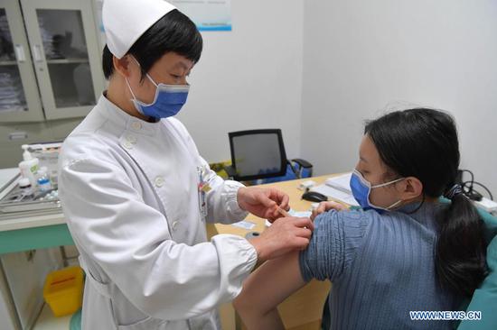 A medical worker administers a COVID-19 vaccine to a woman at Jiangxi Provincial People's Hospital in Nanchang, capital of east China's Jiangxi Province, Jan. 4, 2021. Key groups with higher risks of infection, including frontline medical workers, customs inspectors of imported cold-chain goods and personnel working in the overseas and domestic transportation sector, began to receive their first COVID-19 vaccine doses in Jiangxi Province. (Xinhua/Peng Zhaozhi)