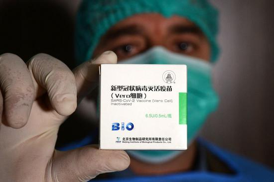 A medical worker shows China's COVID-19 vaccine at a hospital in Peshawar, Pakistan, Feb. 3, 2021. (Photo by Umar Qayyum/Xinhua)