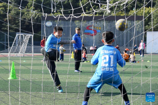 Pupils play football during winter vacation in Renhuai City, southwest China's Guizhou Province, Jan. 18, 2022. (Photo by Chen Yong/Xinhua)