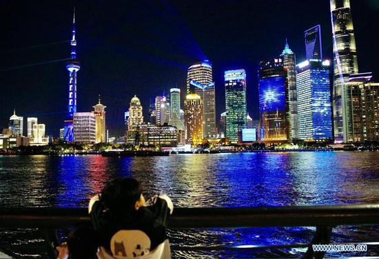 A child views a light show at the Bund in Shanghai, east China, Nov. 4, 2020. A light show themed on the China International Import Expo (CIIE) was held in Lujiazui of Shanghai on Wednesday. (Xinhua/Zhang Yuwei)