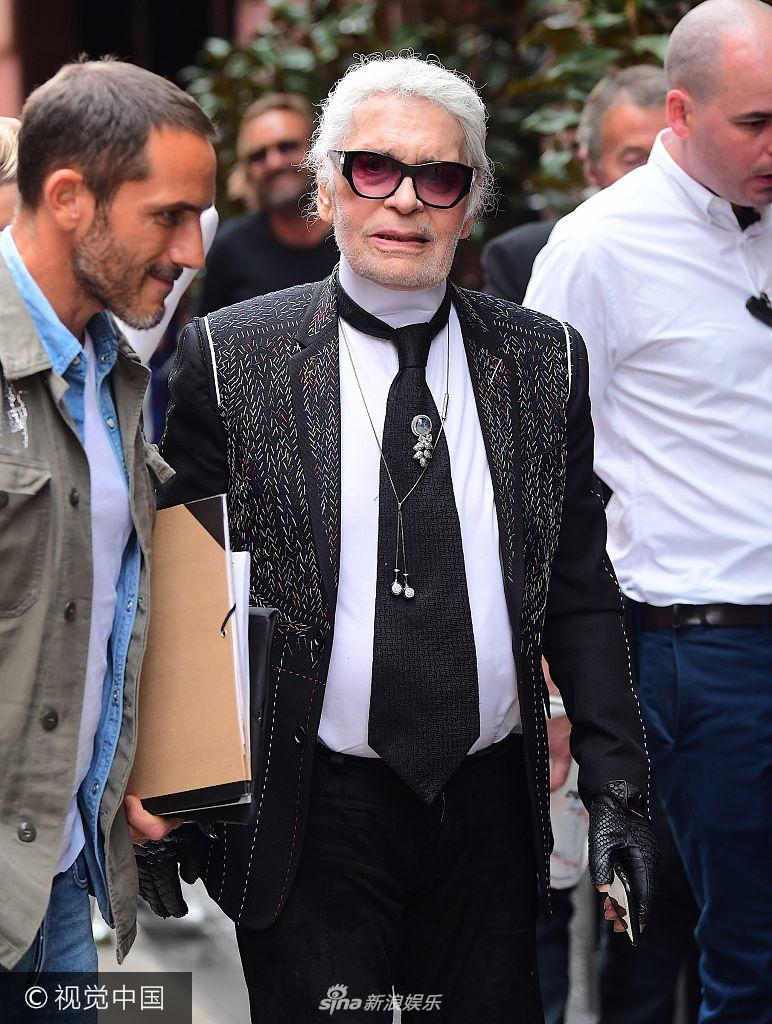 组图:"老佛爷"卡尔坐街边勉强微笑 下颚变宽头发凌乱