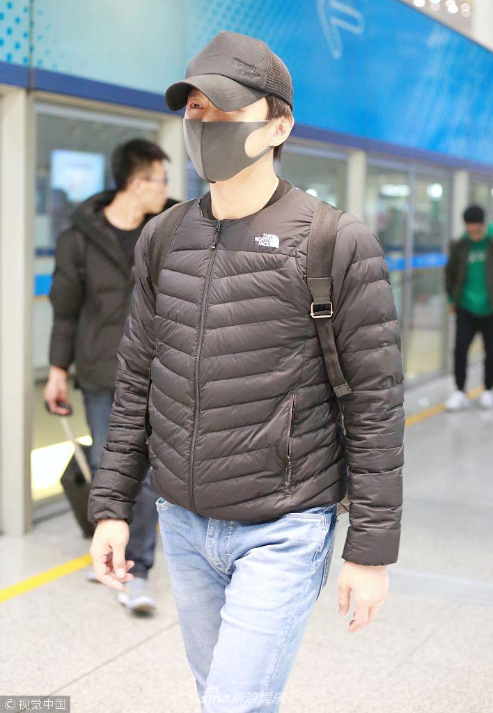 当天他身穿黑色羽绒服,帽子口罩"全副武装",见镜头礼貌打招呼,眼神略