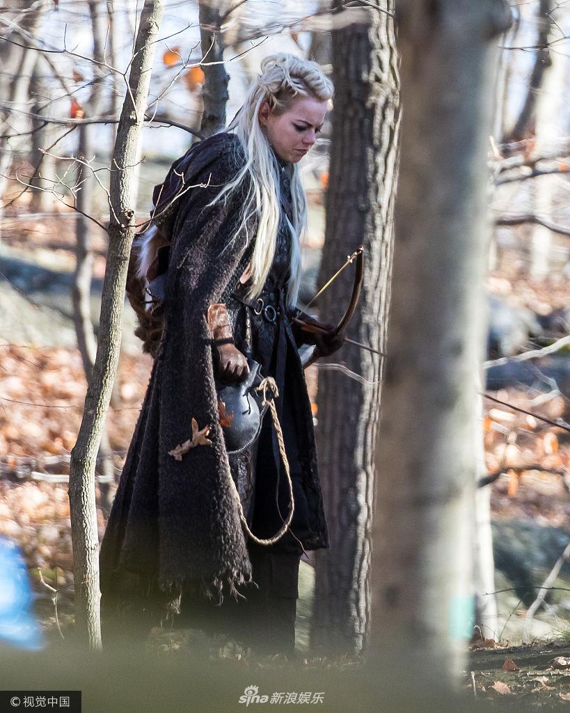 艾玛·斯通穿长袍变森林女战士 持弓箭上演荒野求生