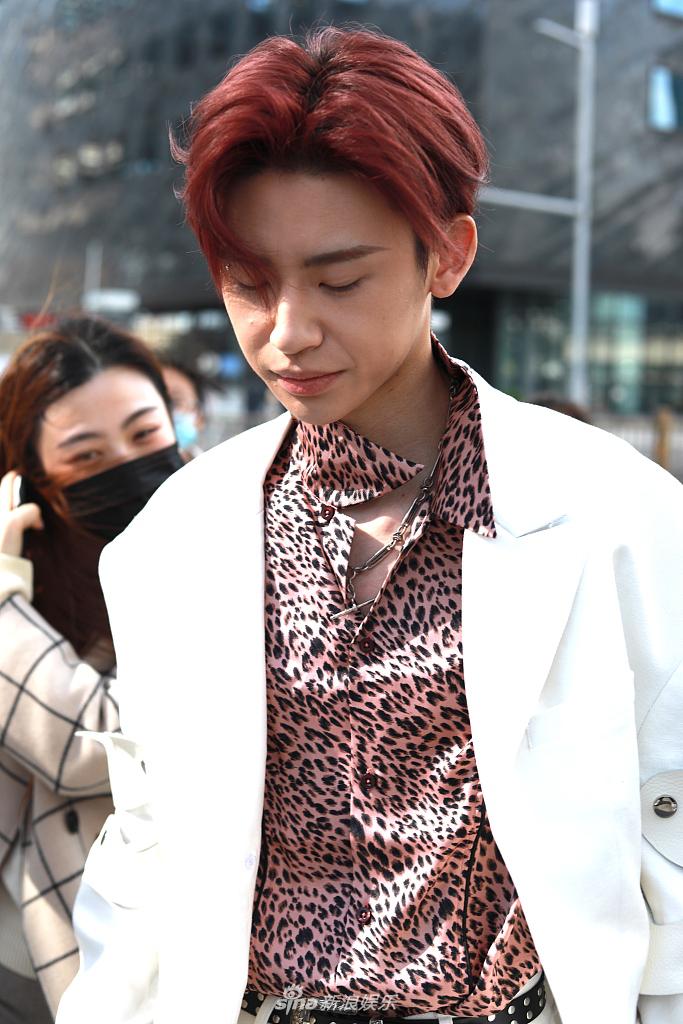 他身着白色西装,内搭粉色豹纹衬衫,顶着红发造型