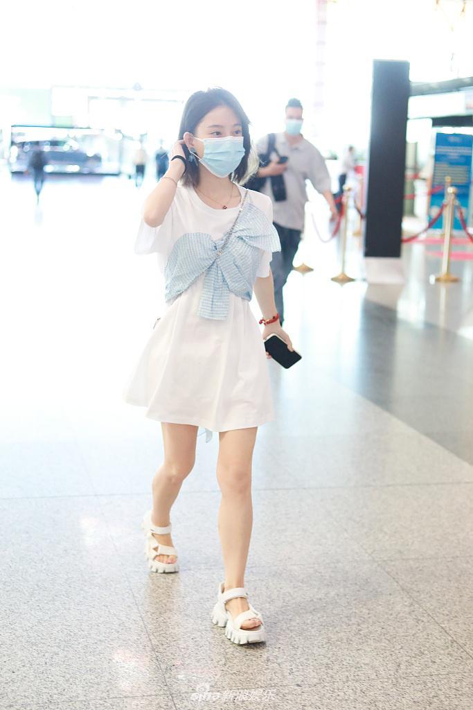 北京,冯提莫现身机场,身穿蓝白拼接风t恤裙简约甜美,搭配白色厚底凉鞋