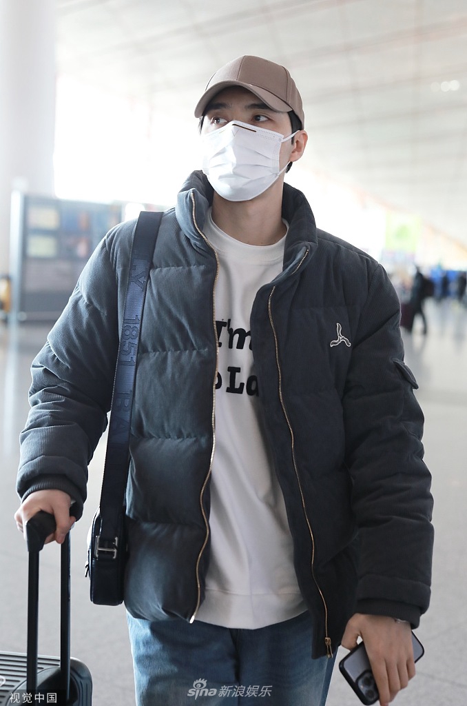 组图阿云嘎现身机场前往跨年晚会穿白t搭棉服帅气休闲