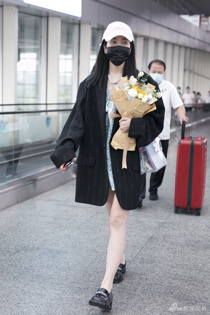 组图乃万身穿蝴蝶结短裙秀美腿手捧花束出行清新靓丽