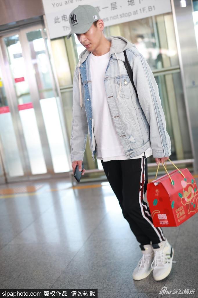 组图:乔振宇独自拎礼品现身机场 挺拔身材配严肃表情一身正气