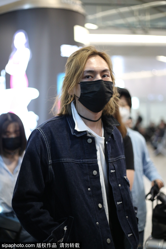 周锐现身机场引迷妹拍照 一头长发飘逸帅气