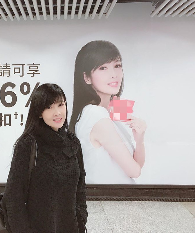 组图:52岁周慧敏与自己的广告牌合照 长发飘逸皮肤白皙