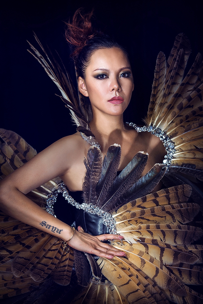 组图:张惠春野性羽毛写真曝光 黝黑皮肤显健康美