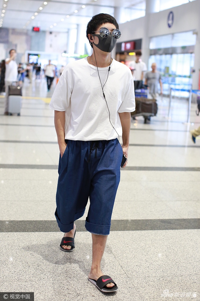 华晨宇白衣阔腿裤装扮清爽 低头玩手机神态自若