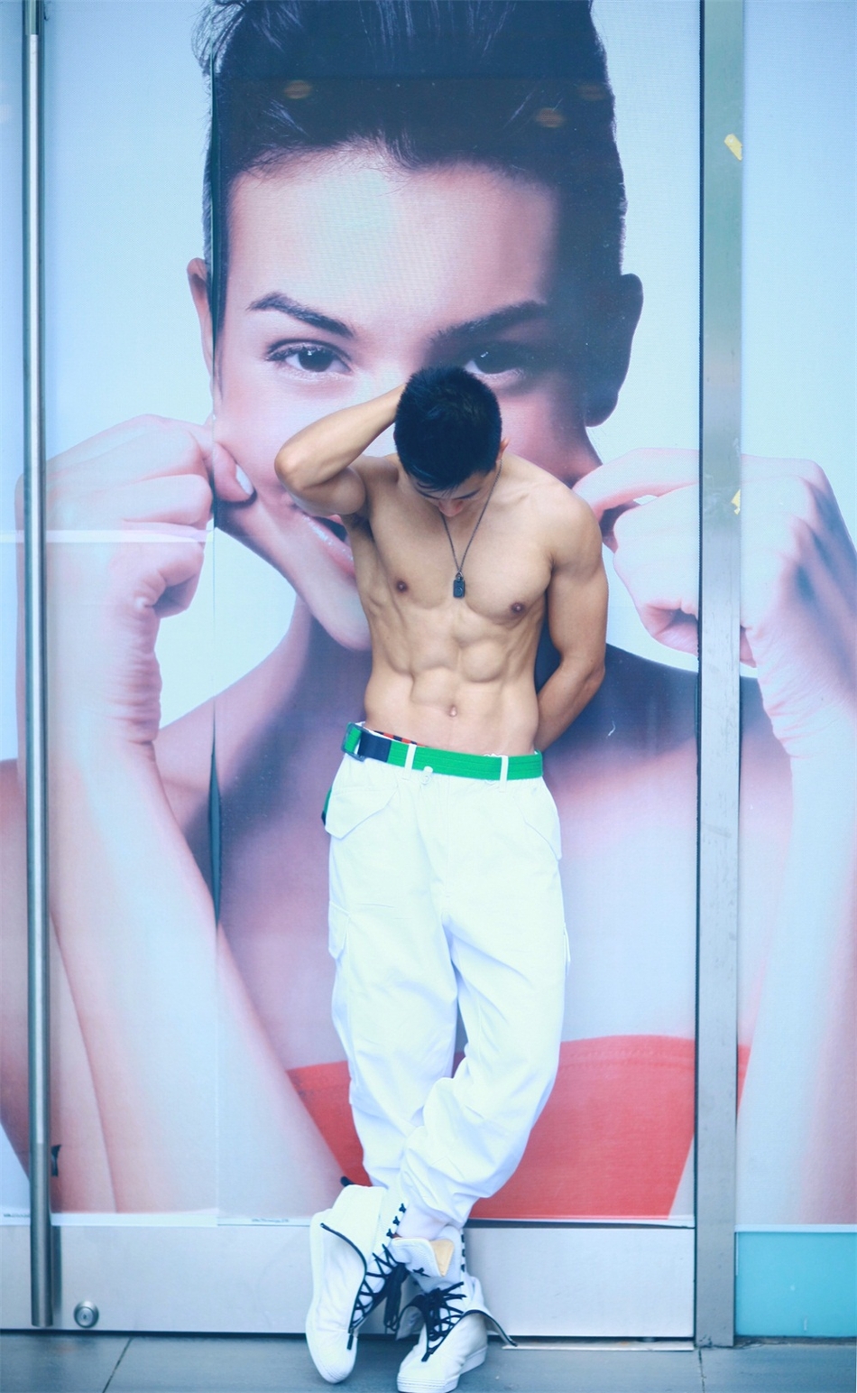 照片中,朱晓辉身着无袖背心搭配白色休闲长裤,悠闲漫步街头,洒脱随性.