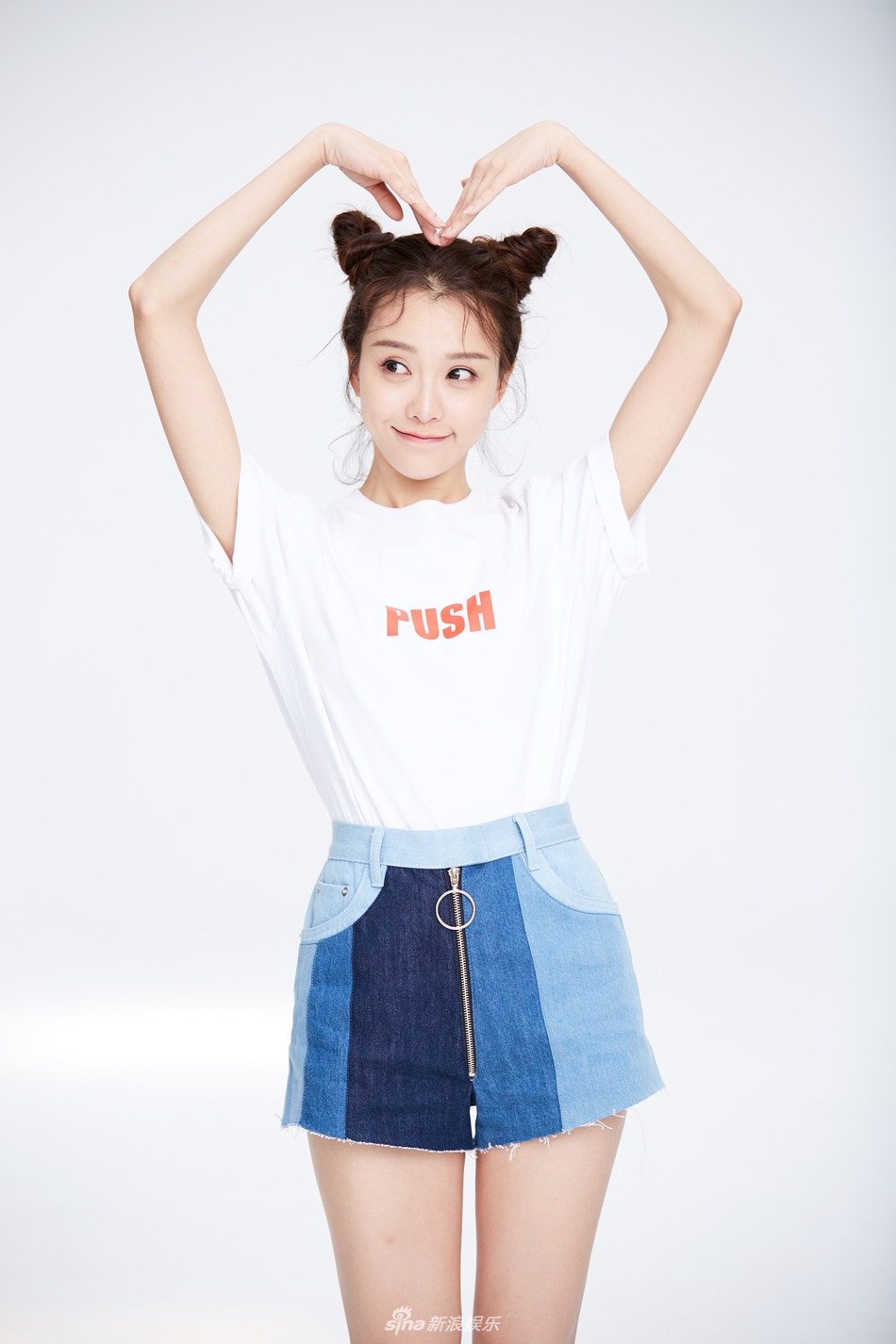 片中,黄一琳身着白色t恤,搭配牛仔布短裙,梳高的双丸子头俏皮可爱