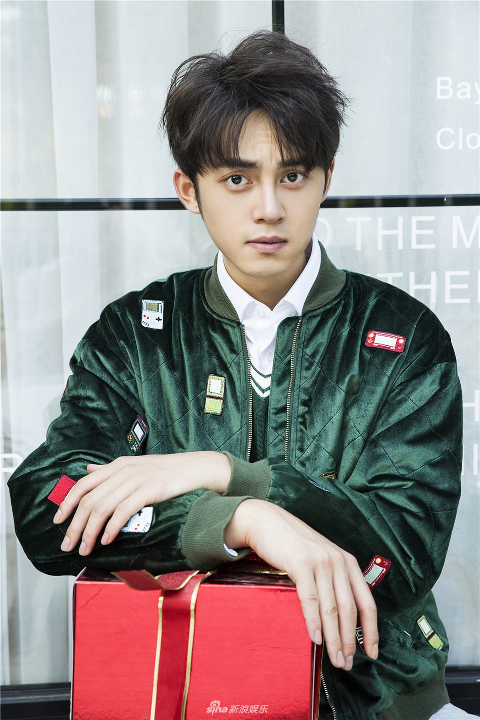 照片中,谢彬彬身着圣诞树色夹克,内搭白色衬衫和绿色背心,下穿浅色