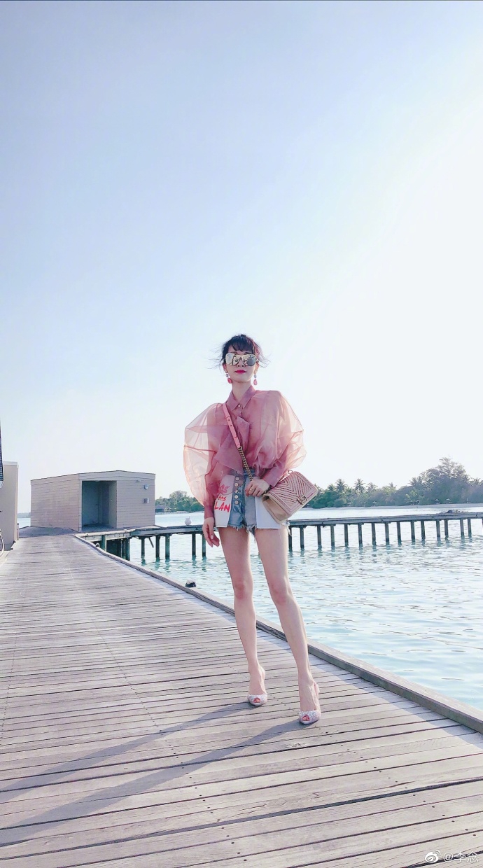 组图:李念海边漫步托腮甜笑状态好 穿牛仔短裤大秀细白美腿