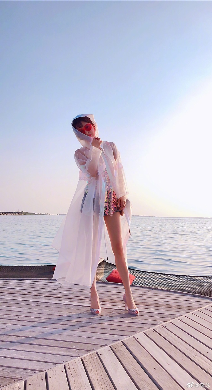 组图:李念海边漫步托腮甜笑状态好 穿牛仔短裤大秀细白美腿