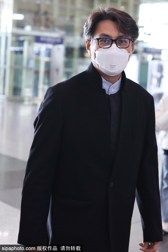组图：靳东着黑色大衣现身机场 戴黑框眼镜看镜头很是亲切