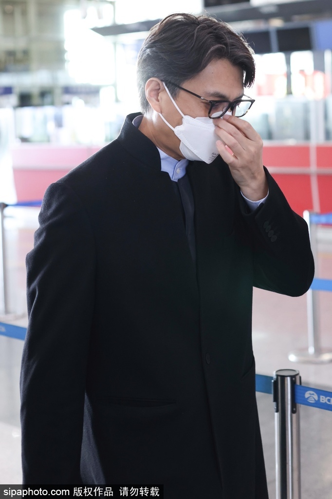 组图：靳东着黑色大衣现身机场 戴黑框眼镜看镜头很是亲切