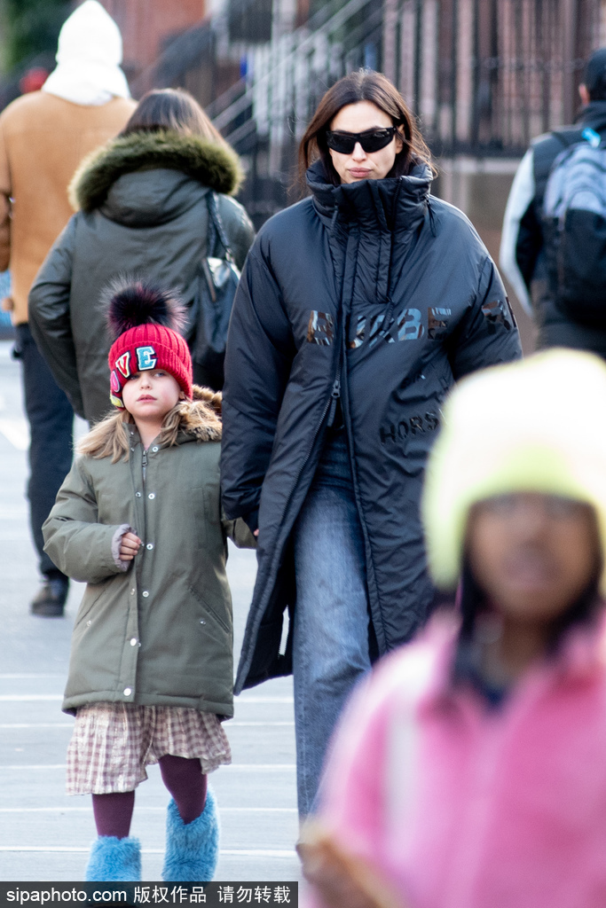 组图：伊莉娜沙伊克裹黑色长款棉服带女儿上学 穿搭保暖且时尚