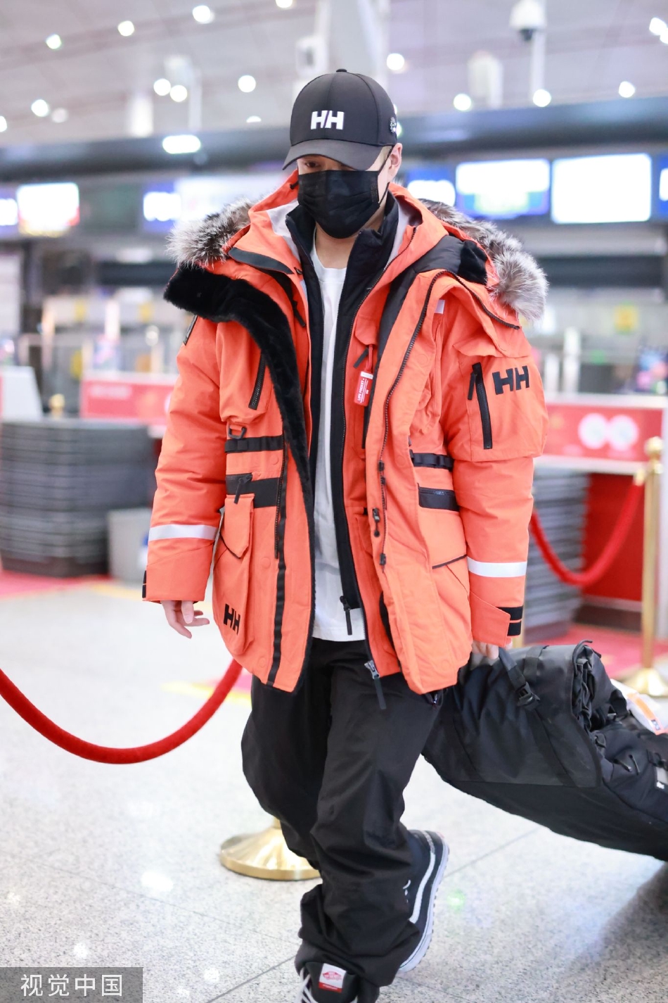 组图：韩东君橘色山地服现身机场 潮酷鸭舌帽时尚帅气