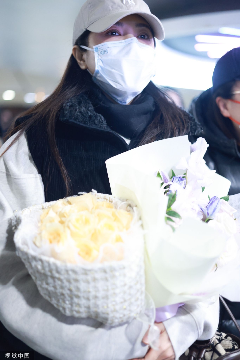 组图：曾黎穿白色卫衣配马甲现身机场 获粉丝赠花面带灿笑气质好