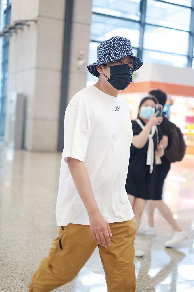组图:秦昊穿白t配休闲裤亮相机场 搭渔夫帽显时尚