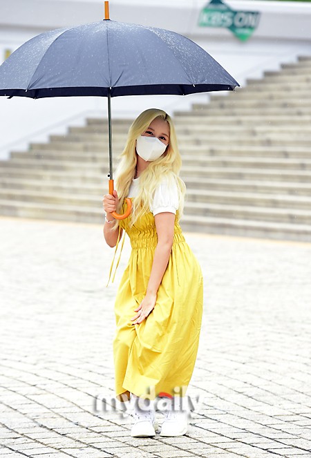 組圖：宇宙少女任多榮穿黃裙色彩明豔 雨中撐傘去上班