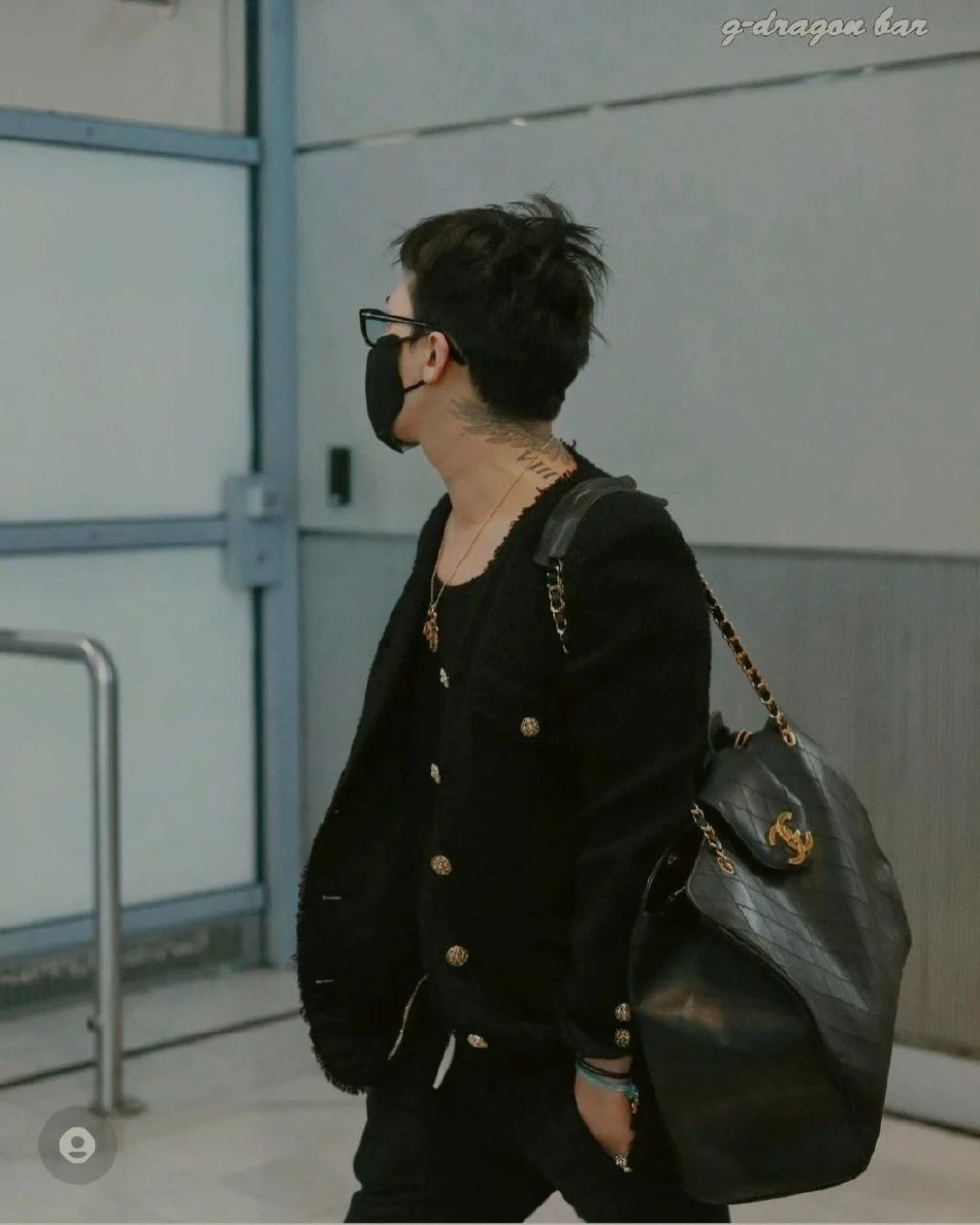 组图：权志龙穿女装背大包现身机场 绿色指甲新纹身抢镜