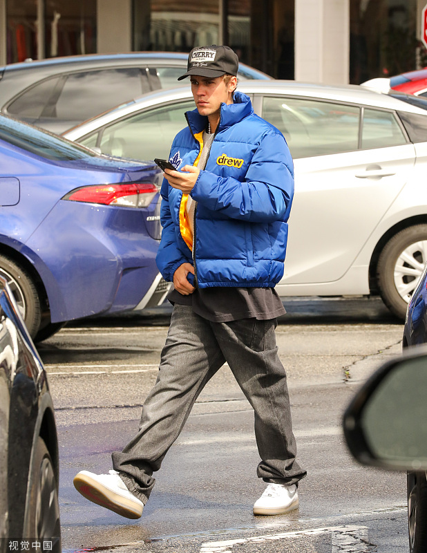 组图:贾斯汀·比伯穿蓝色棉服出街 低头拨弄手机休闲随性_高清图集