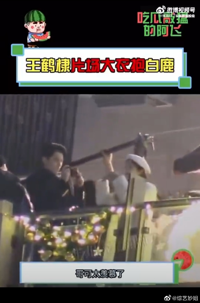 组图：《以爱为营》片场王鹤棣大衣抱白鹿 用手机给对方拍照