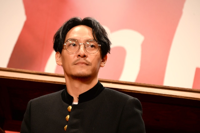 张震黑衣黑裤脚踏白球鞋简约帅气,梳中分发型戴眼镜儒雅十足