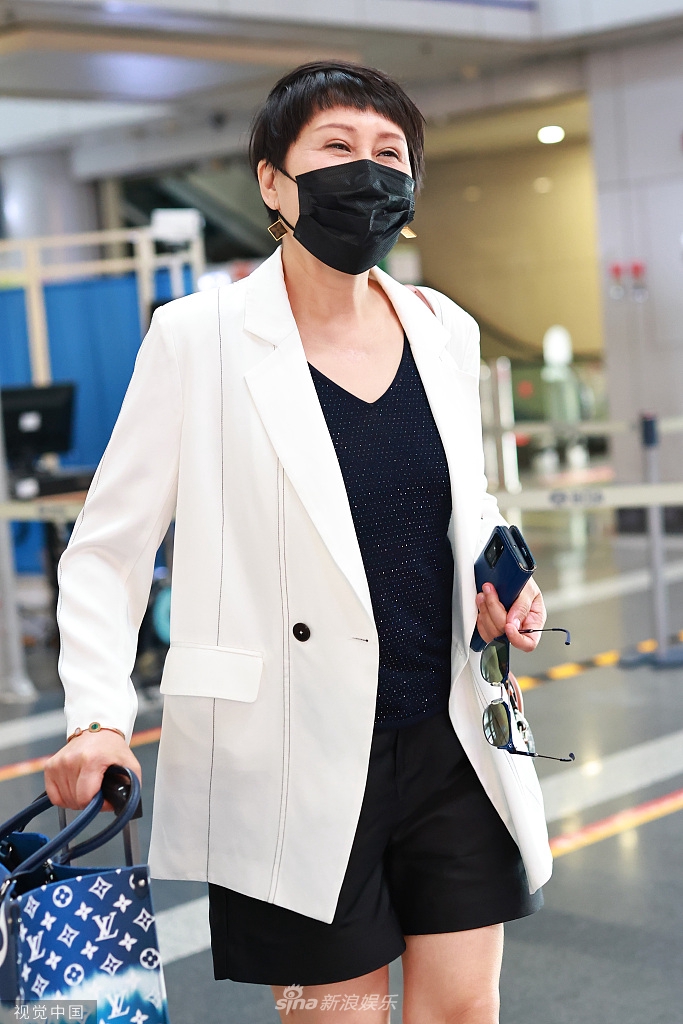 组图:张凯丽白色西装搭v领上衣知性干练 见镜头摘墨镜打招呼