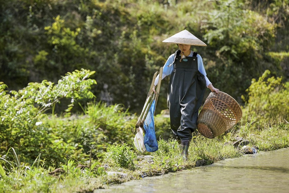 组图:张子枫化身摄影小能手 体验捕鱼装静享自然田园乐趣