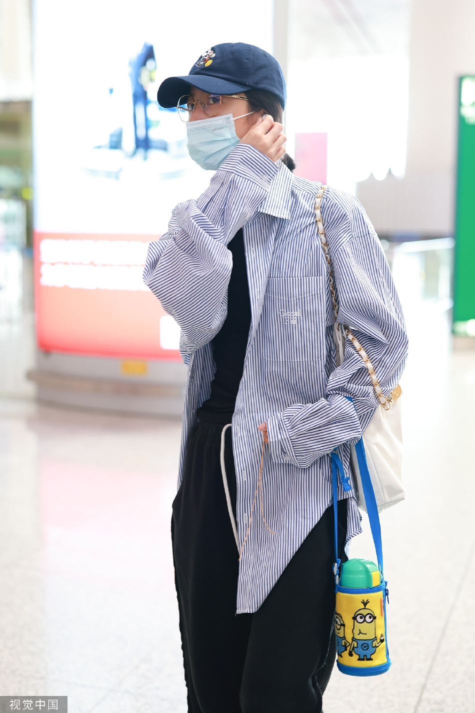 组图：演员周雨彤现身北京机场穿蓝白条纹衬衫清爽休闲第2张图片