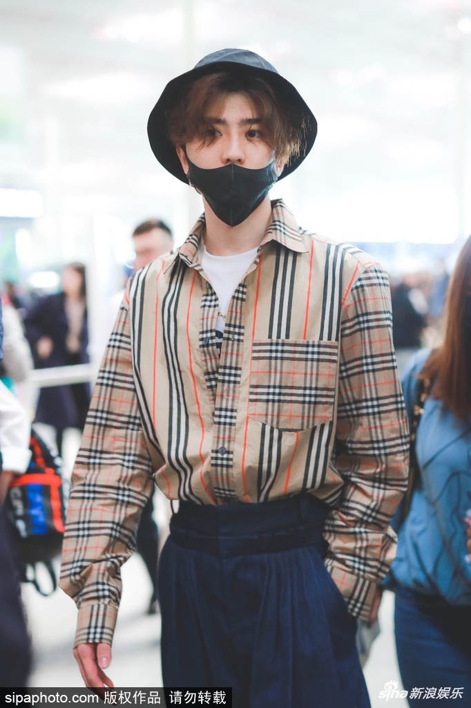 组图:蔡徐坤穿格子衬衫现身机场 头发微卷单手插兜酷劲十足
